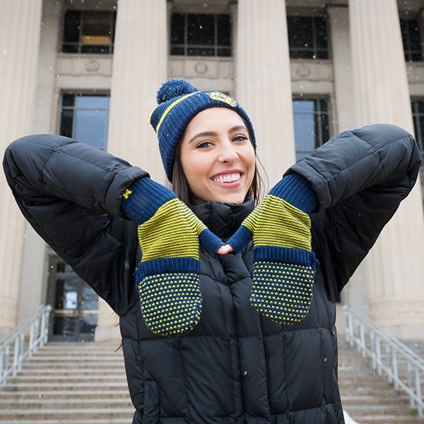 Woman wearing University of Michigan gloves and hat