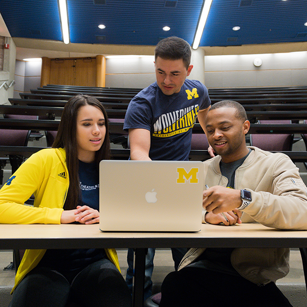 University of Michigan students looking at a laptop